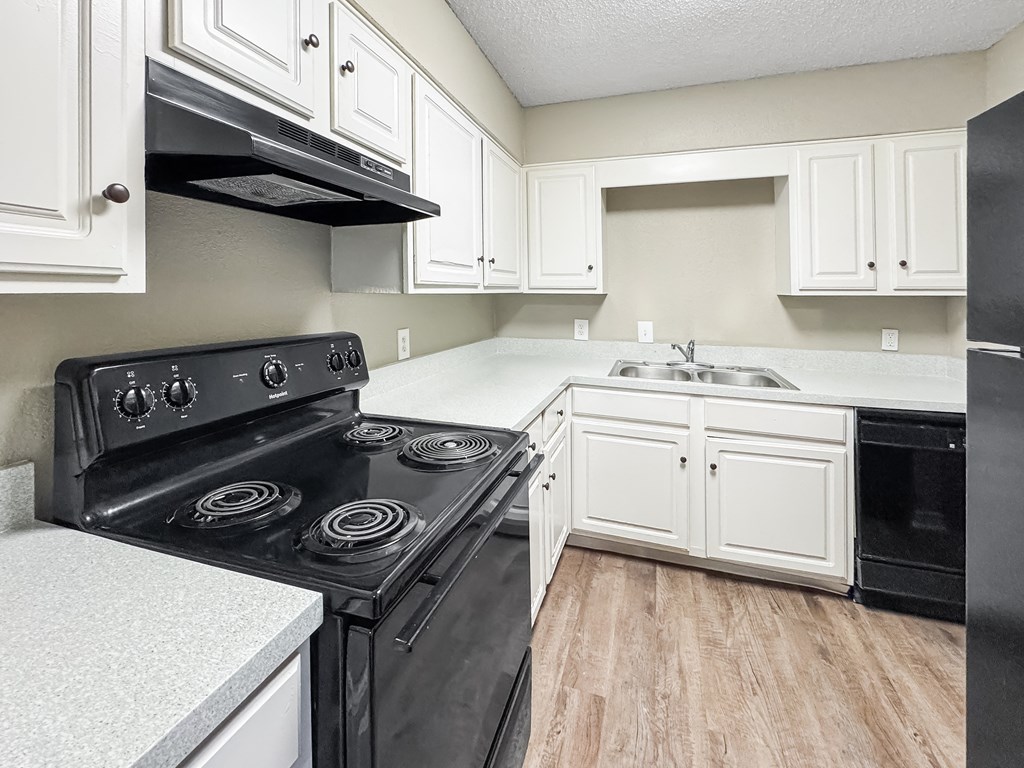 Kitchen with white cabinets and black appliances at Verano Oaks Apartments