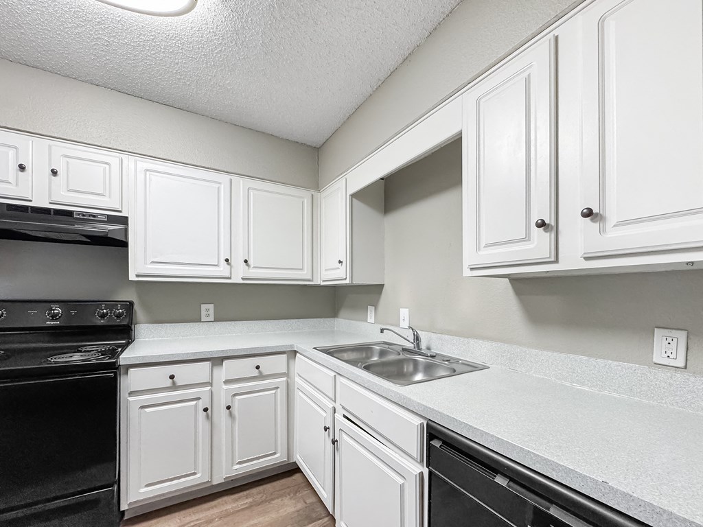 Kitchen with white cabinets and black appliances at Verano Oaks Apartments