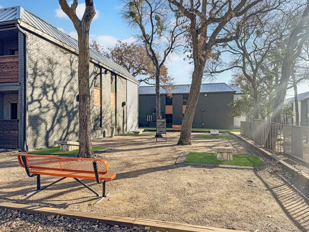 Corn hole area with tables under trees at Verano Oaks Apartments in Hurst, TX