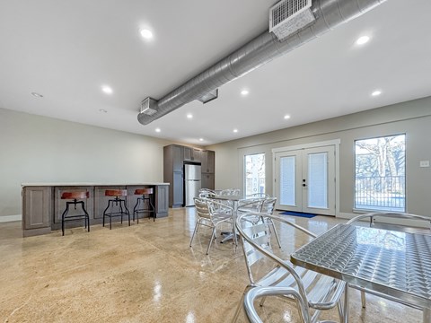 A spacious dining area with a bar and chairs.