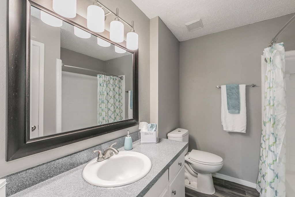 Bathroom with wide mirror, vanity lighting, and updated fixtures