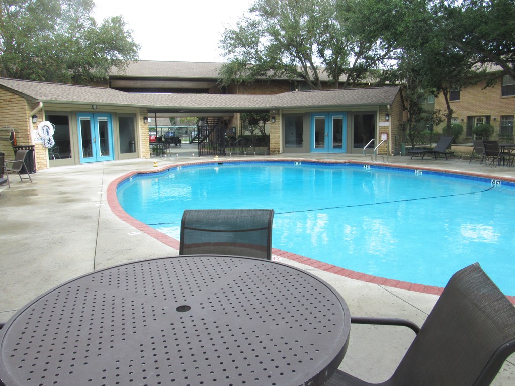 a swimming pool with a table and chairs around it