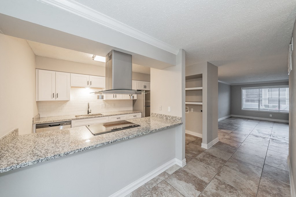 Apartment kitchen featuring upgraded appliances and lighting