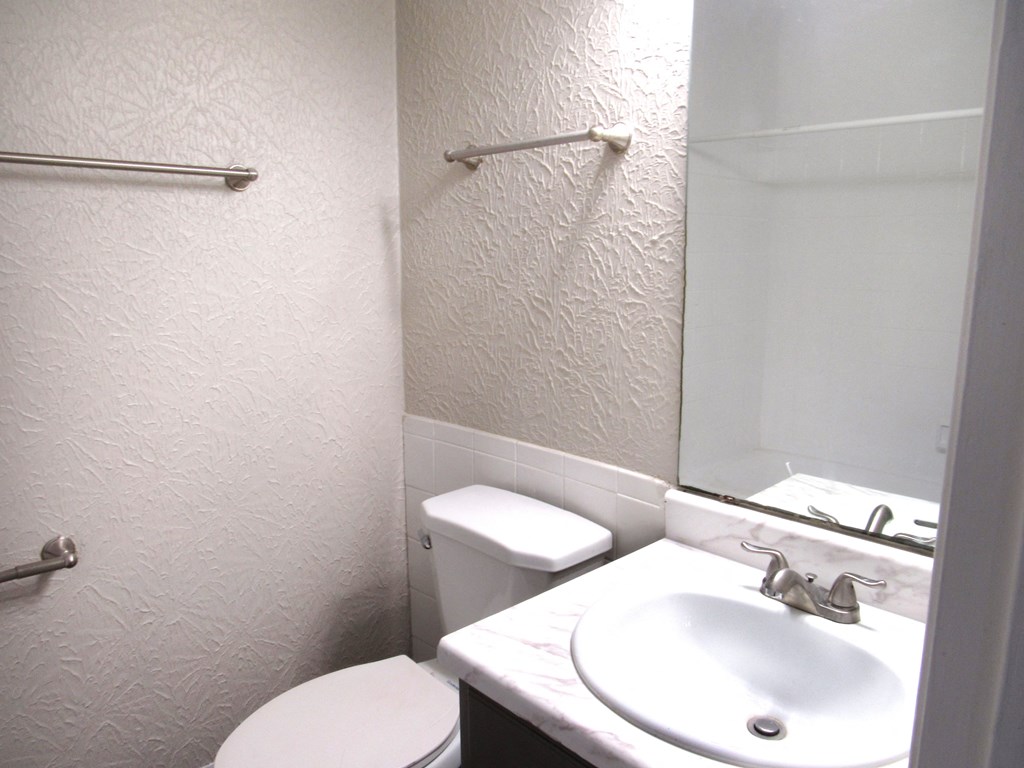 a small bathroom with a sink toilet and mirror