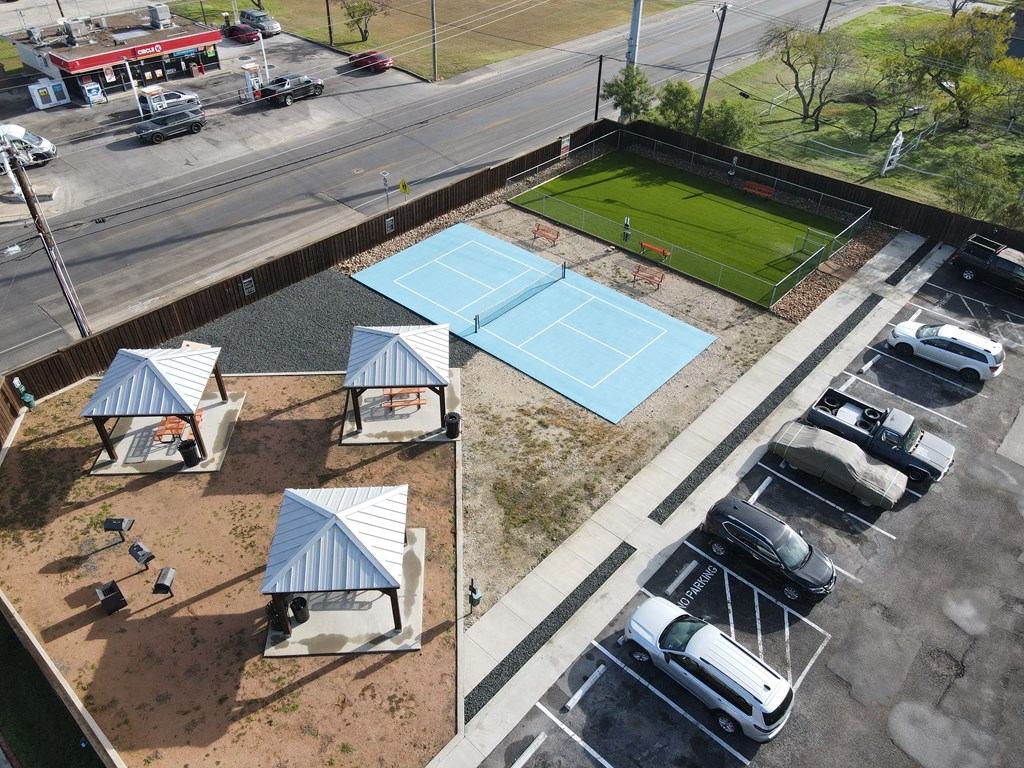 an aerial view of a tennis court and pavilion on the roof of a building