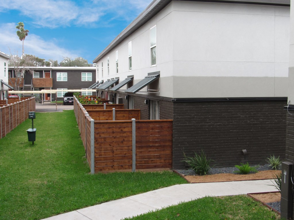 Back lawn and fenced patio area at Christy Estates Apartments