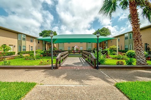 Courtyard walkway with green canopy at Greenbriar Place Apartments in Corpus Christi.