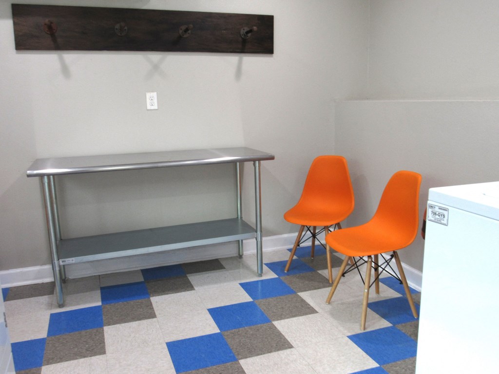 a room with two orange chairs and a desk in it