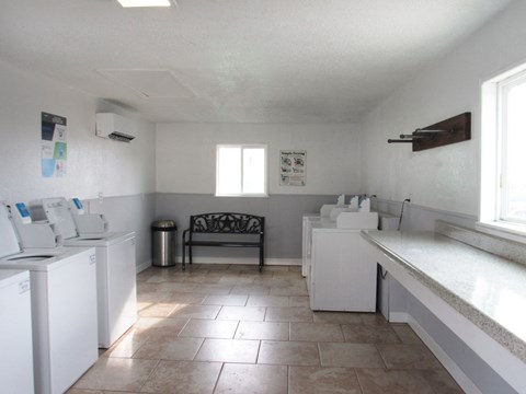 a kitchen with white appliances and a chair in the corner