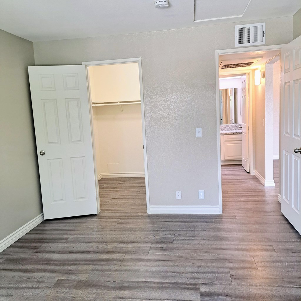 A room with a white door and a wooden floor at Raintree Apartments, CA 92346