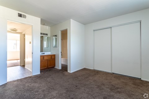 A room with a brown carpet and white walls.