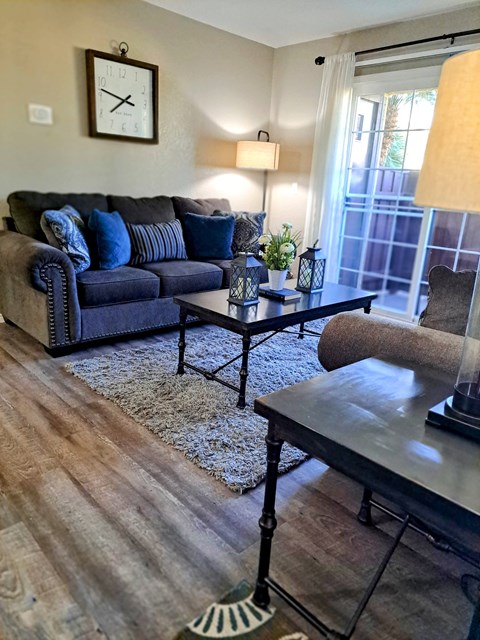 A living room with a blue couch and a coffee table.