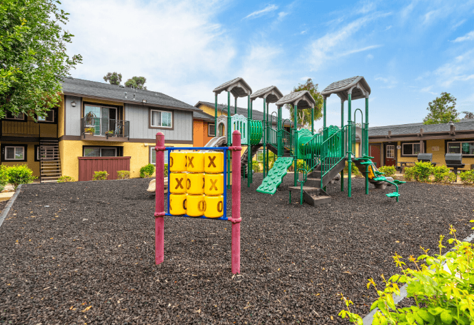 A playground with a sign that says at Raintree Apartments, CA 92346