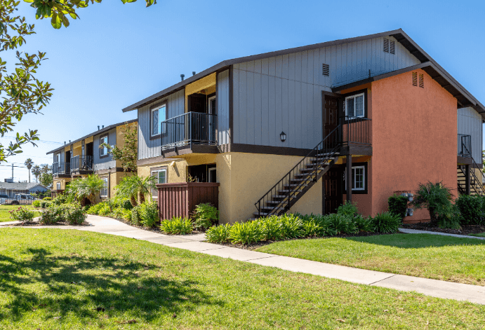 A building with a balcony and stairs leading to the second floor at Raintree Apartments, CA 92346