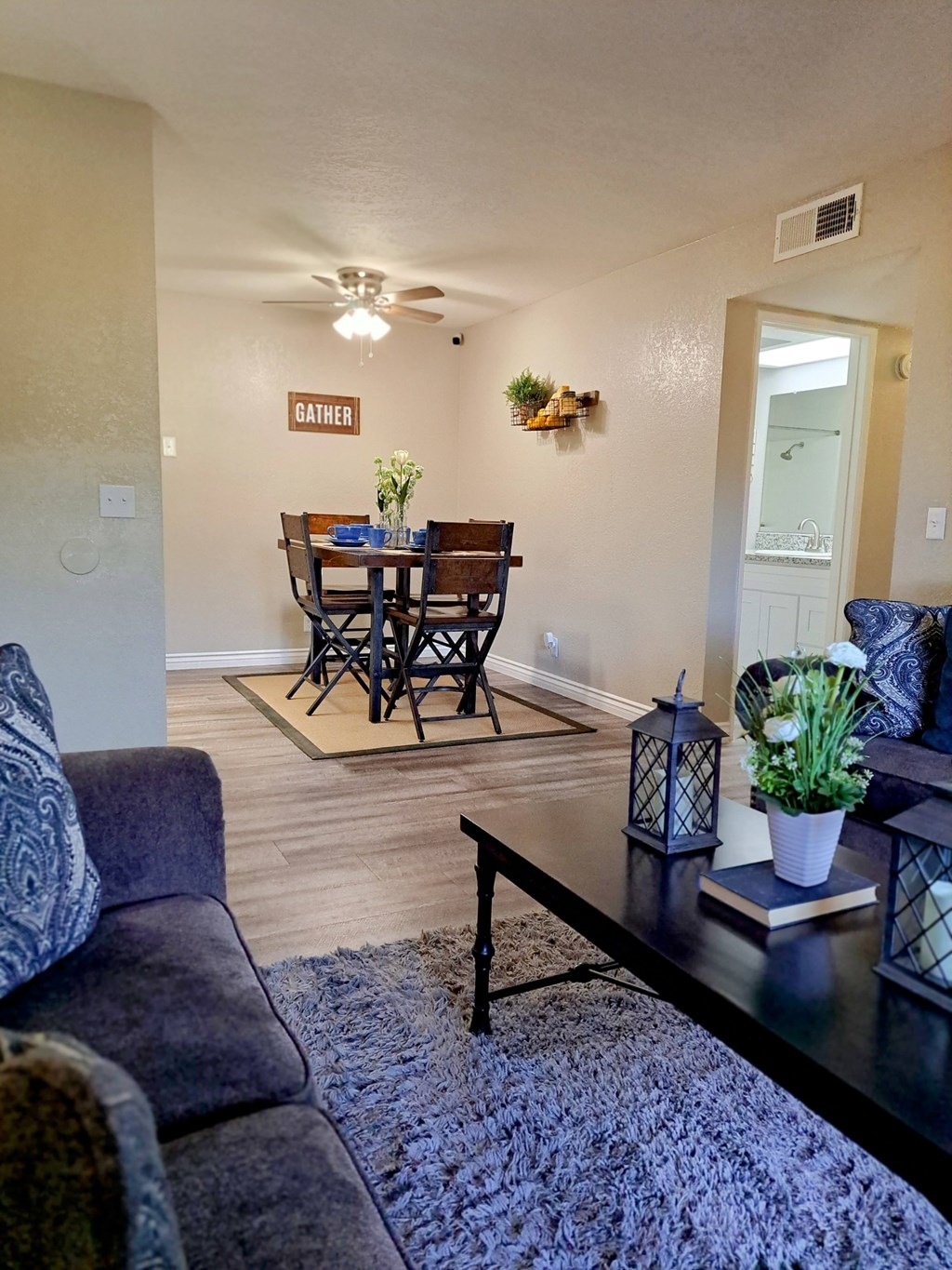 A living room with a dining table and chairs at Raintree Apartments, CA 92346