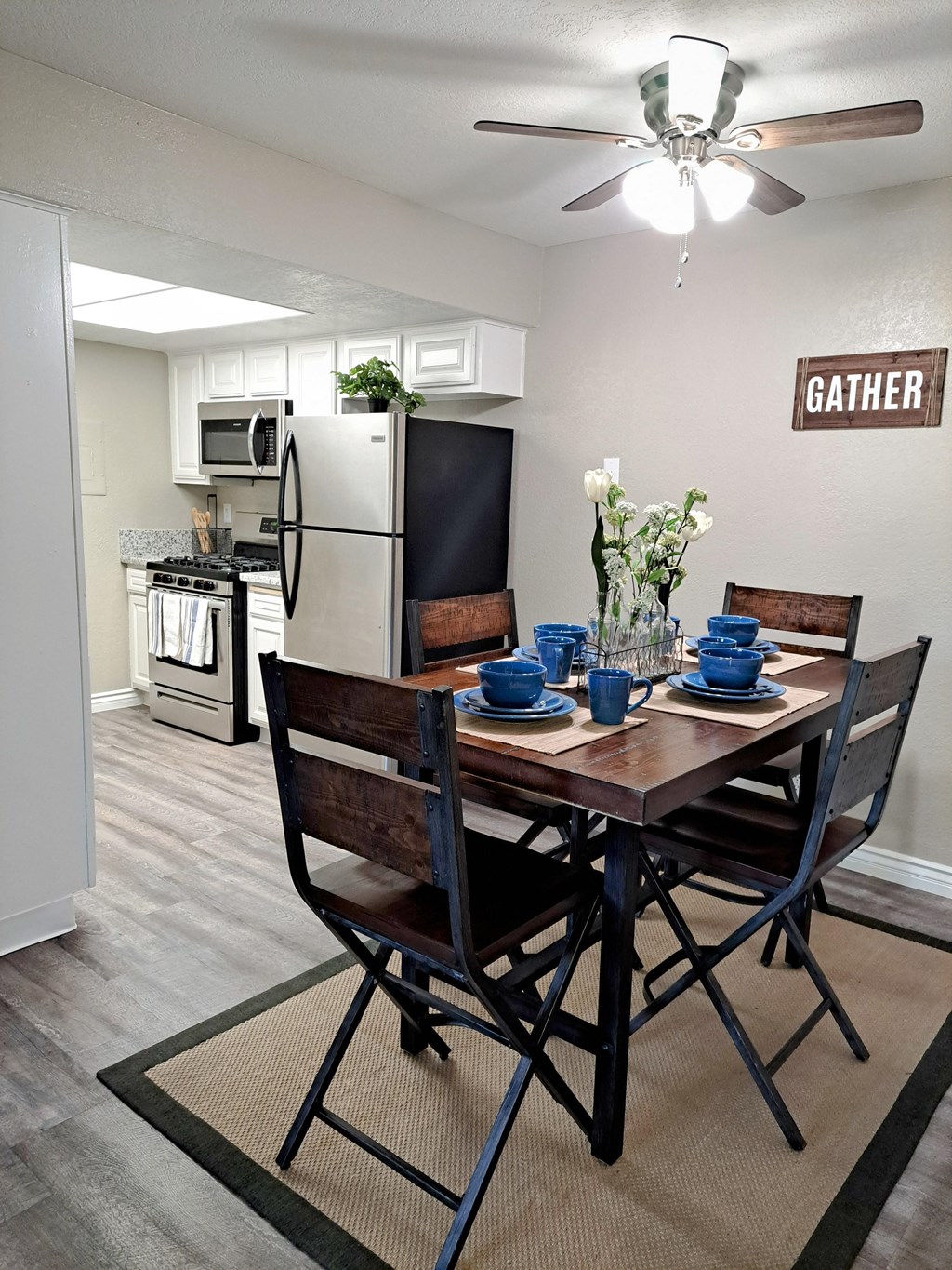 A dining room with a table set for two and a sign that says at Raintree Apartments, CA 92346