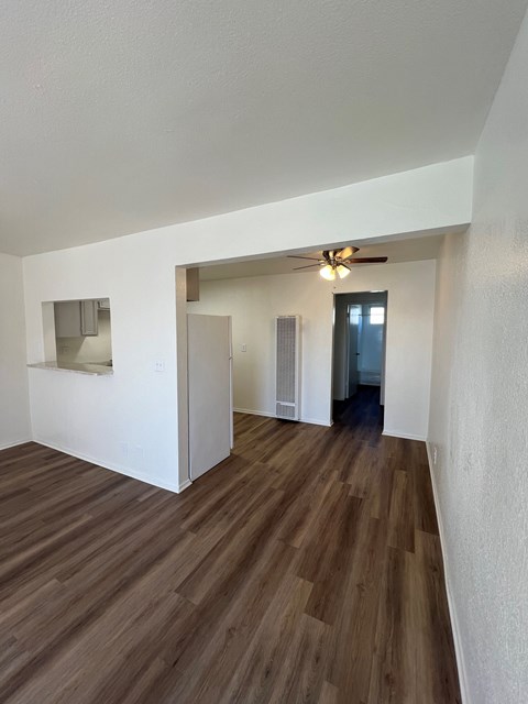 A room with wooden floors and a ceiling fan.
