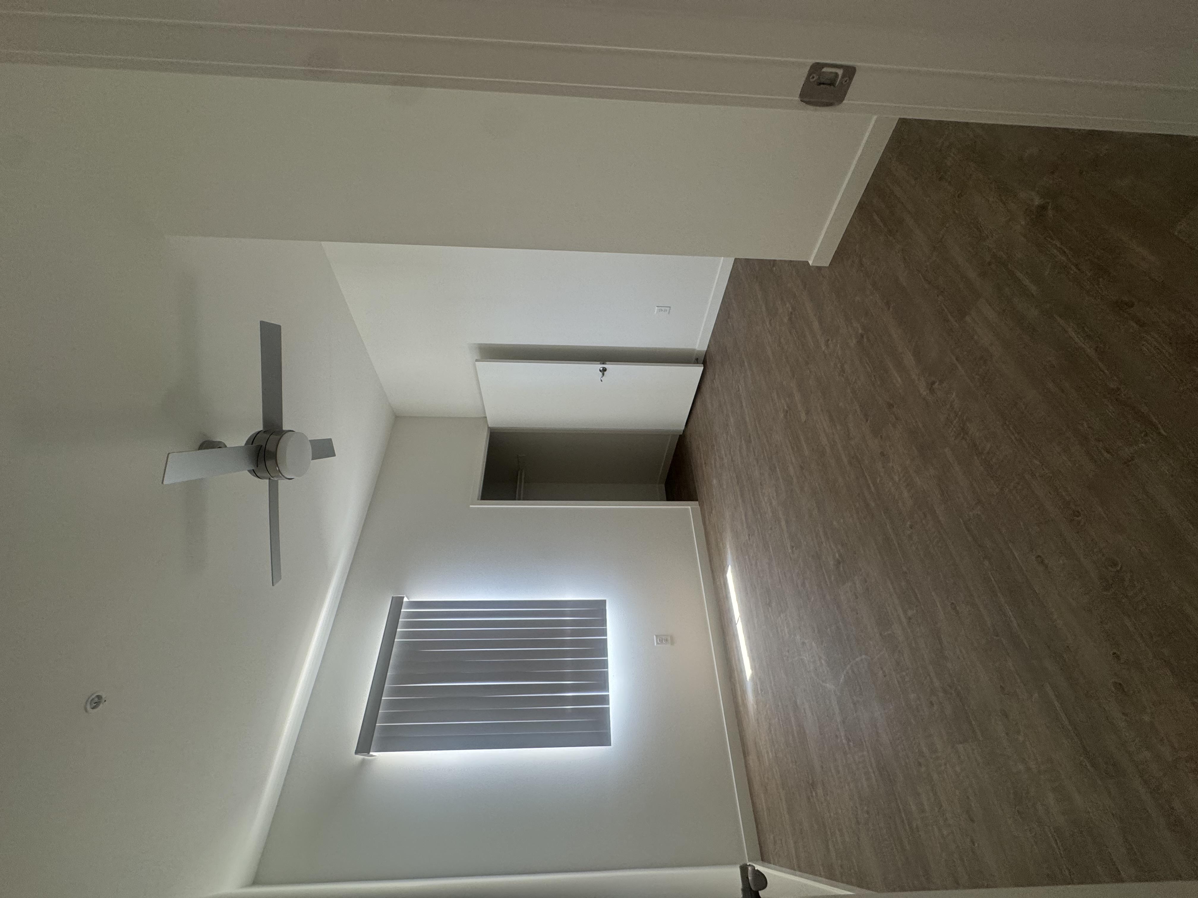 A ceiling fan is mounted on a white ceiling.
