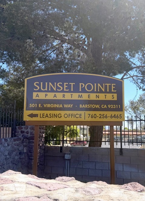 A sign for Sunset Pointe Apartments with a leasing office phone number.