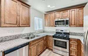 A kitchen with wooden cabinets and a granite countertop.