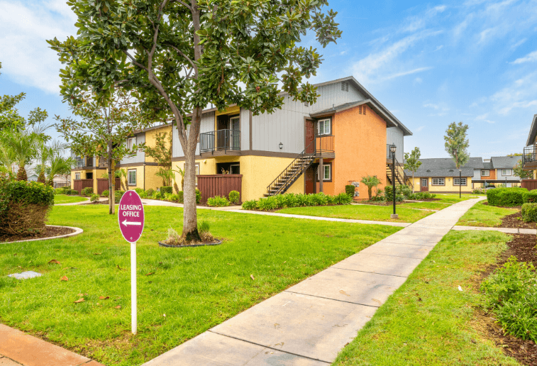 A sign in front of a building that says at Raintree Apartments, CA 92346