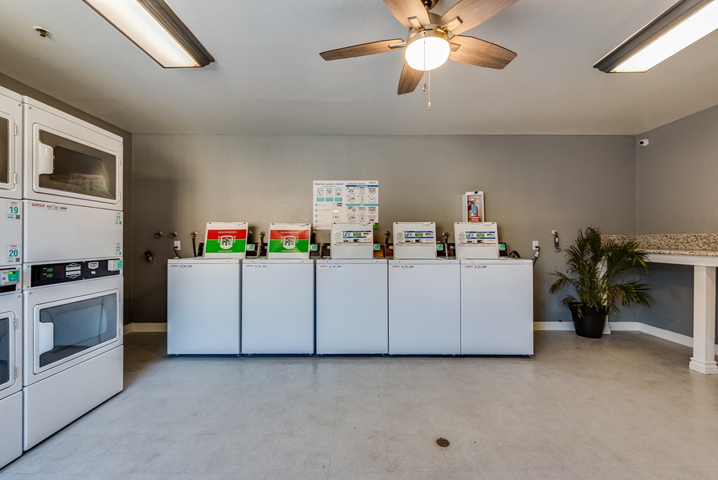 a kitchen with white appliances and a ceiling fan