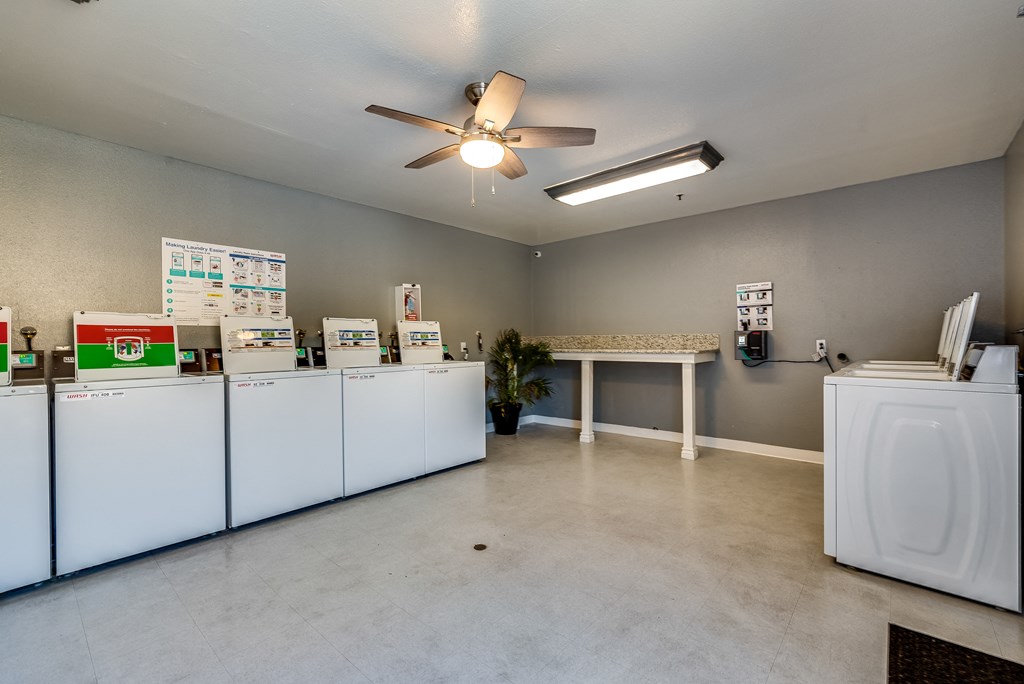a laundry room with machines and a ceiling fan