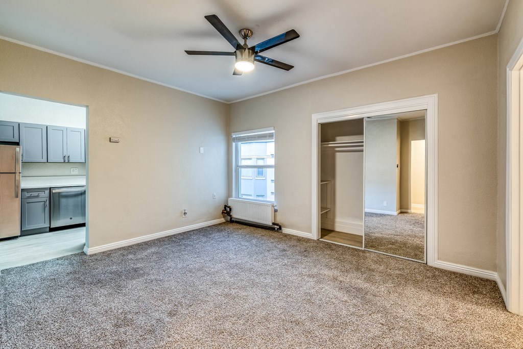 a bedroom with a ceiling fan and a large mirror