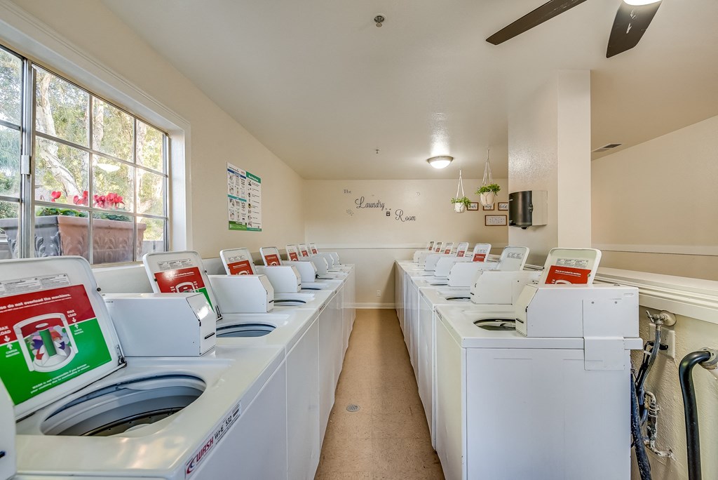 a laundry room with white washers and dryers
