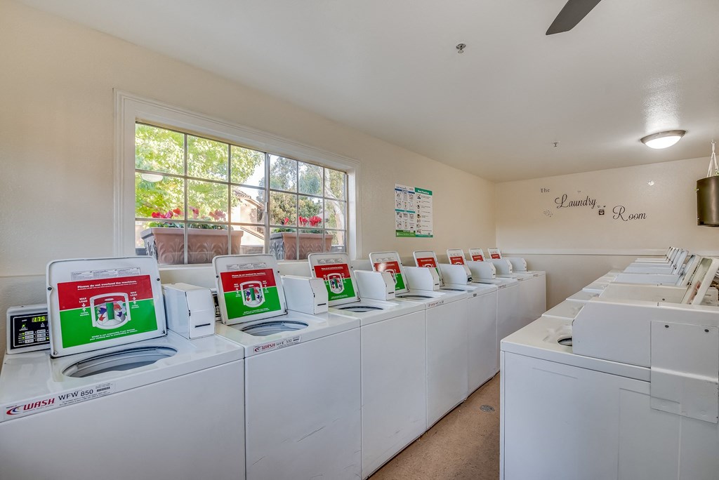 a laundry room with white washers and dryers
