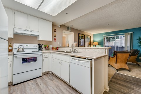 a kitchen with white appliances and a counter top and a sink