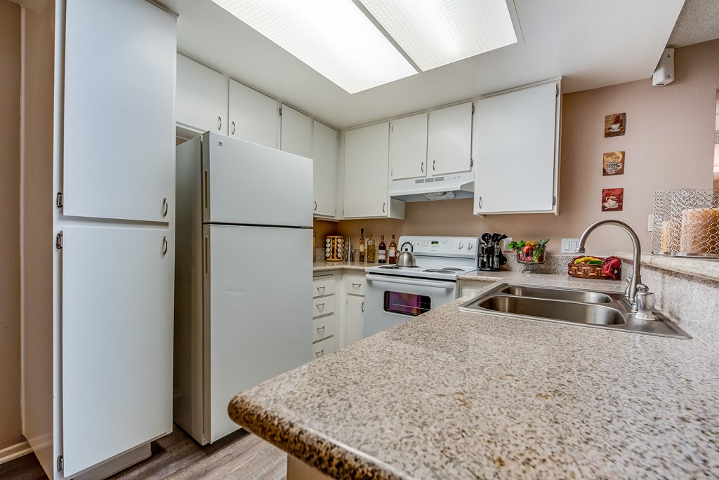 a kitchen with white cabinets and a granite counter top