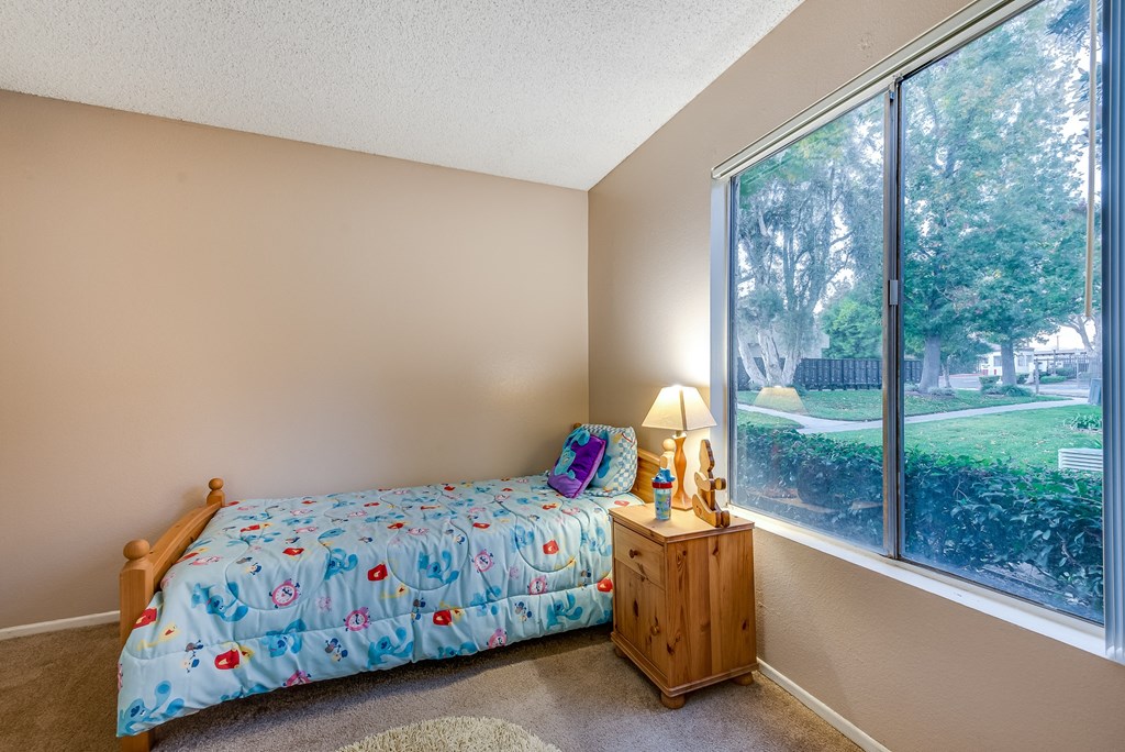 a bedroom with a bed and a large window