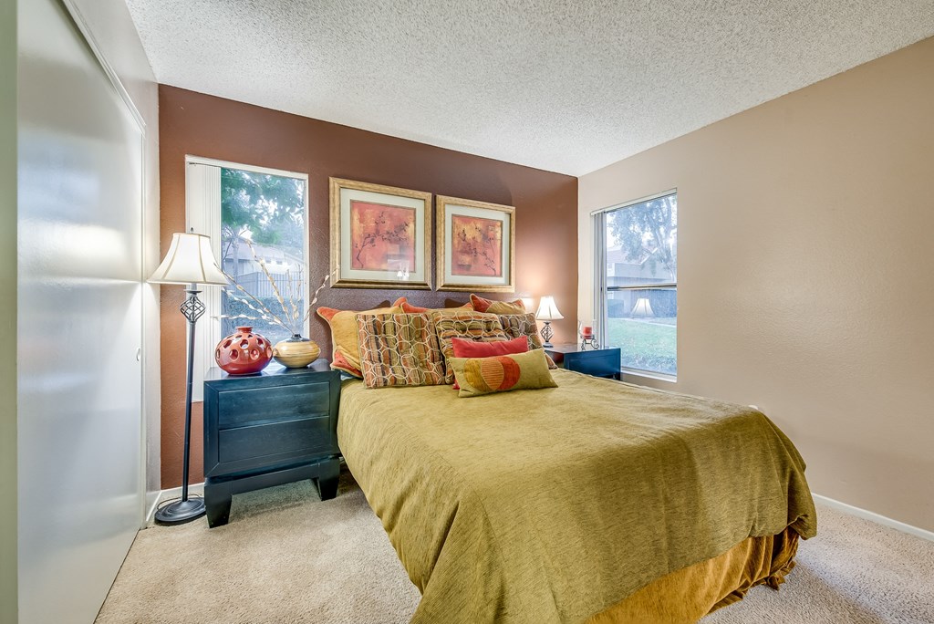 a bedroom with brown walls and a yellow bedspread