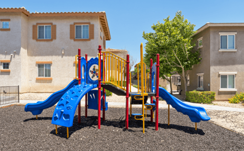 A playground with a blue slide and a yellow and red structure.