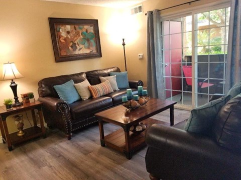 A living room with a brown leather couch and a wooden coffee table.