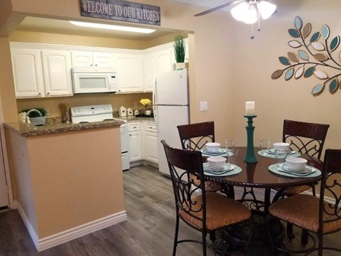 A kitchen with a table set for four.