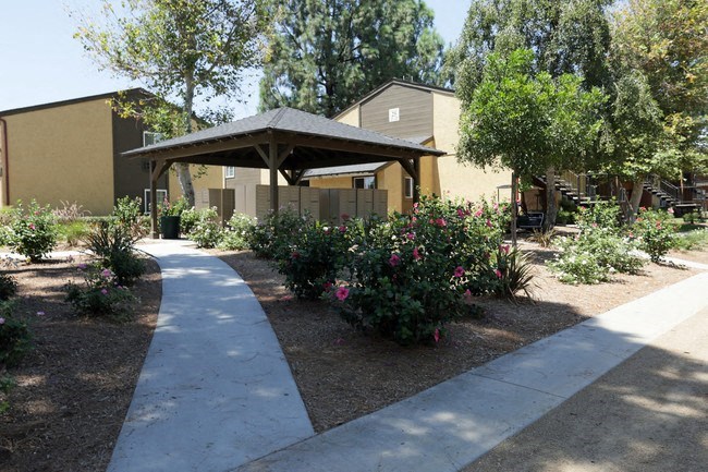 a gazebo sits in the middle of a garden
