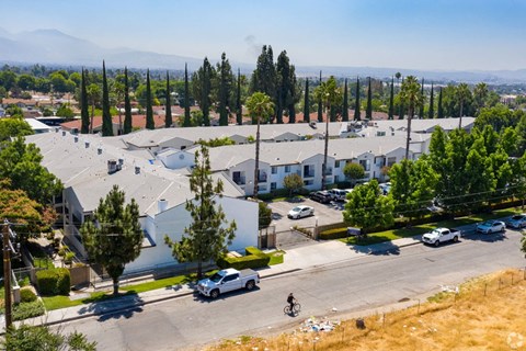 an aerial view of a neighborhood with houses and cars and trees