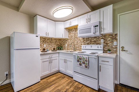 a kitchen with white appliances and a microwave