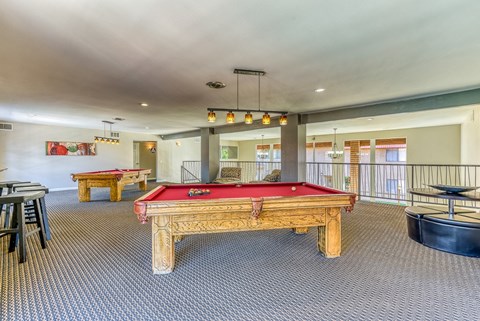 A room with a pool table and a billiard table.