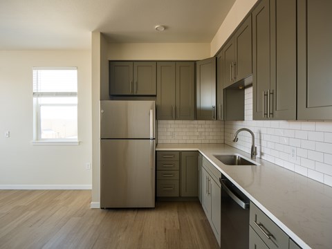 A kitchen with a stainless steel refrigerator and dark wood cabinets.