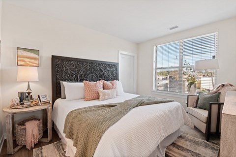 Cozy bedroom with large window and queen size bed in luxury Main Line apartment