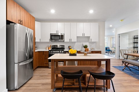 A modern kitchen with a wooden table and chairs.