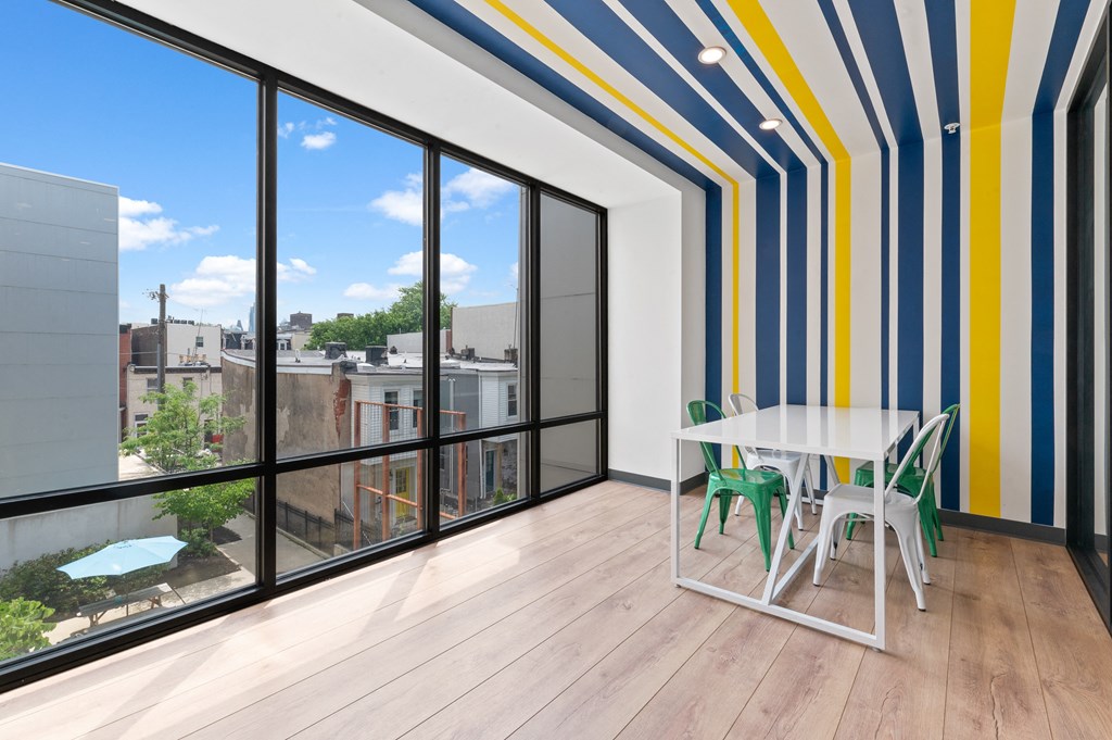 Tables and chairs in private study pod with large windows and sunny, outdoor view