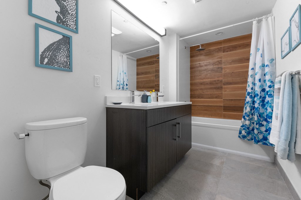 Modern bathroom with white tub and wood tiled shower with rainfall showerhead