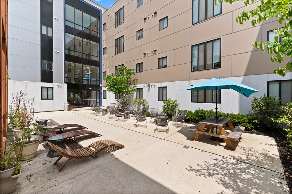 Spacious outdoor courtyard with lounge chairs at University City student apartments