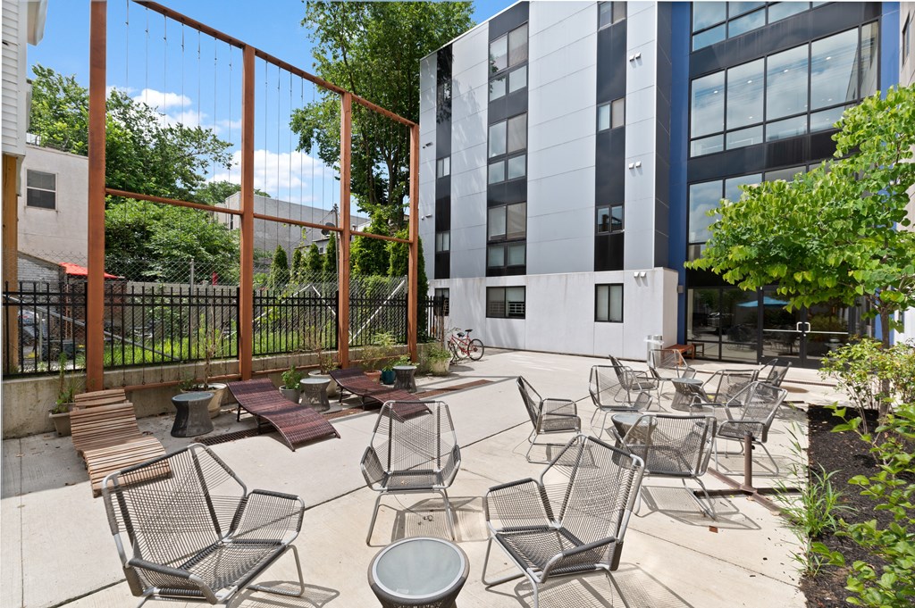 Outdoor courtyard with lounge chairs, tables, and chairs at UPenn off-campus apartments