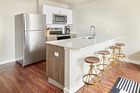 a kitchen with a white counter top and a stainless steel refrigerator
