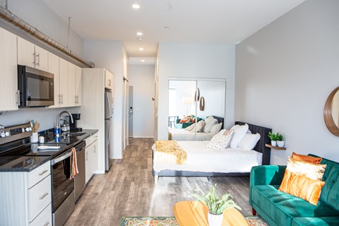 a bedroom with a bed and a kitchen and a living room